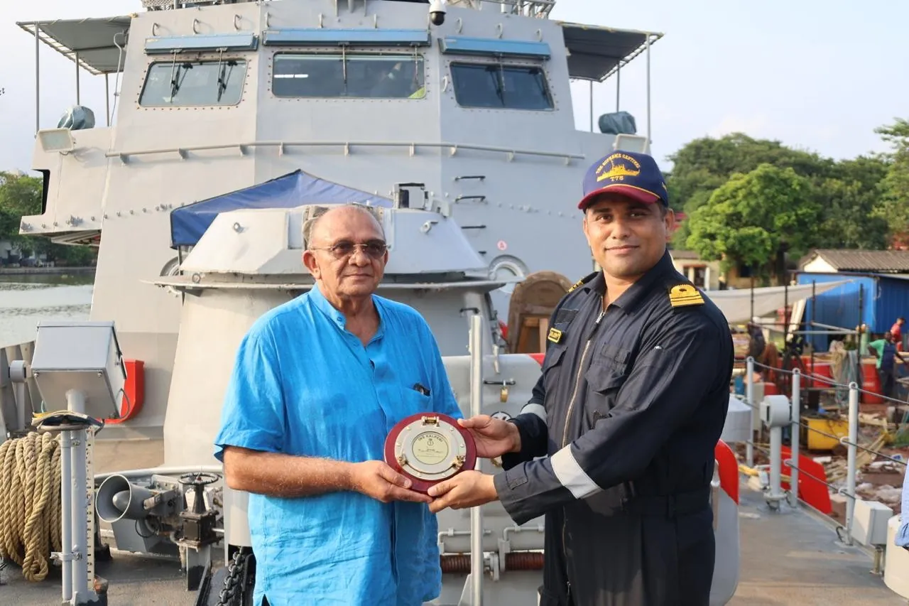 Mr Kiran Sanghvi presenting a project plaque to a naval officer onboard INS Kalpeni.