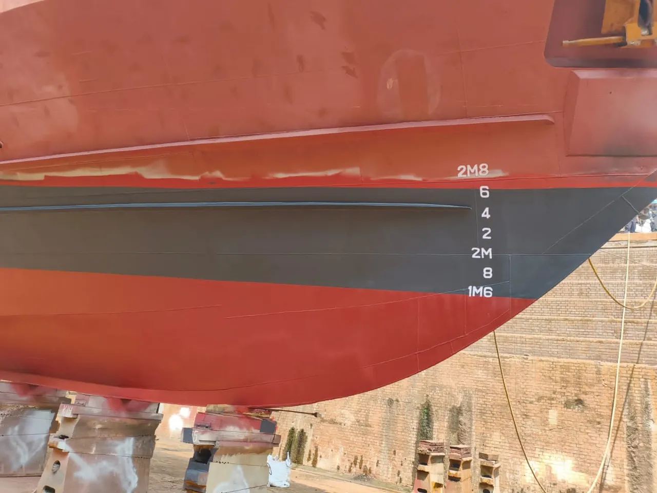 Completed underwater-hull coating and renewed draft marks.
