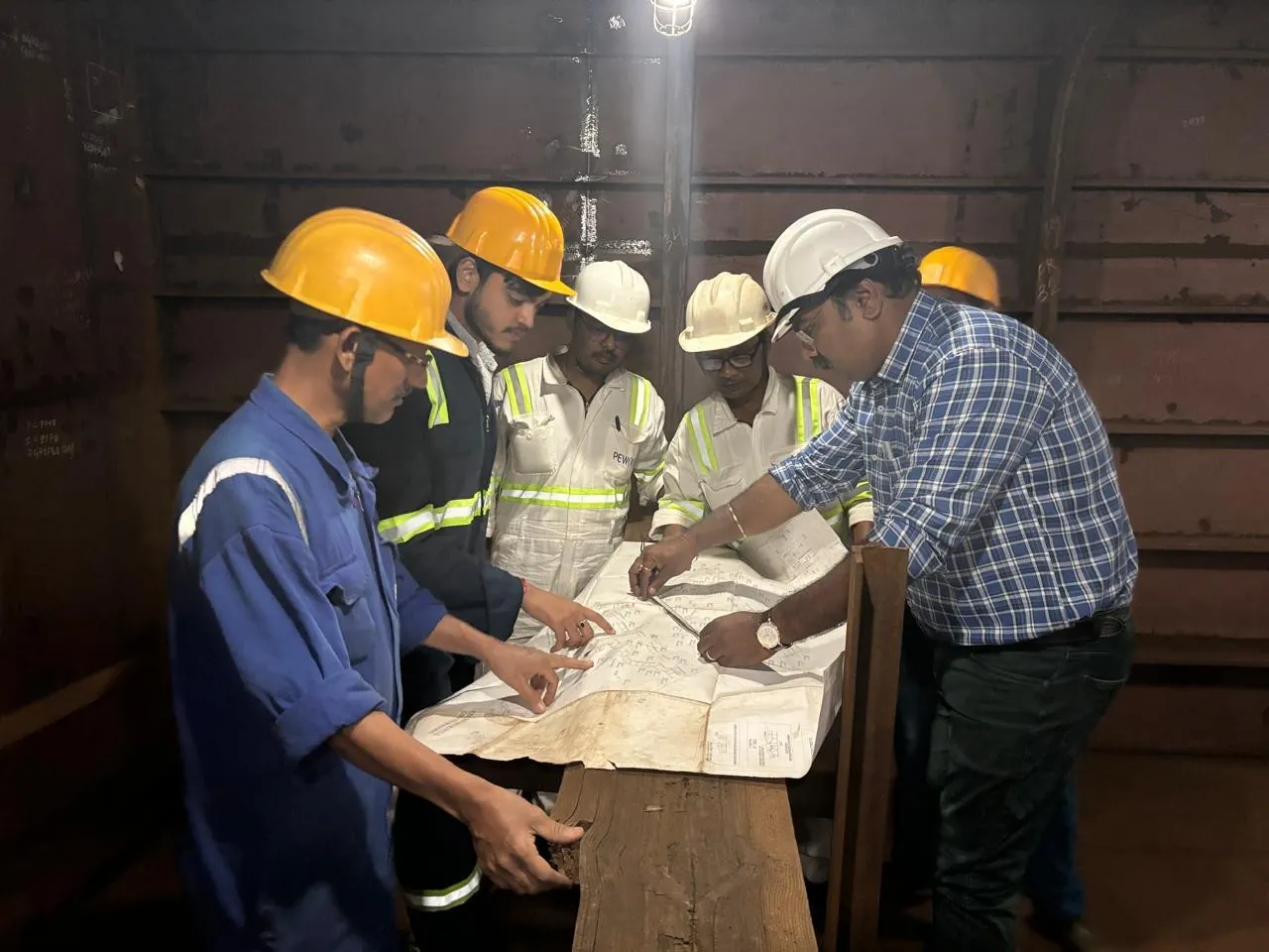 PEWV personnel reviewing production drawings.