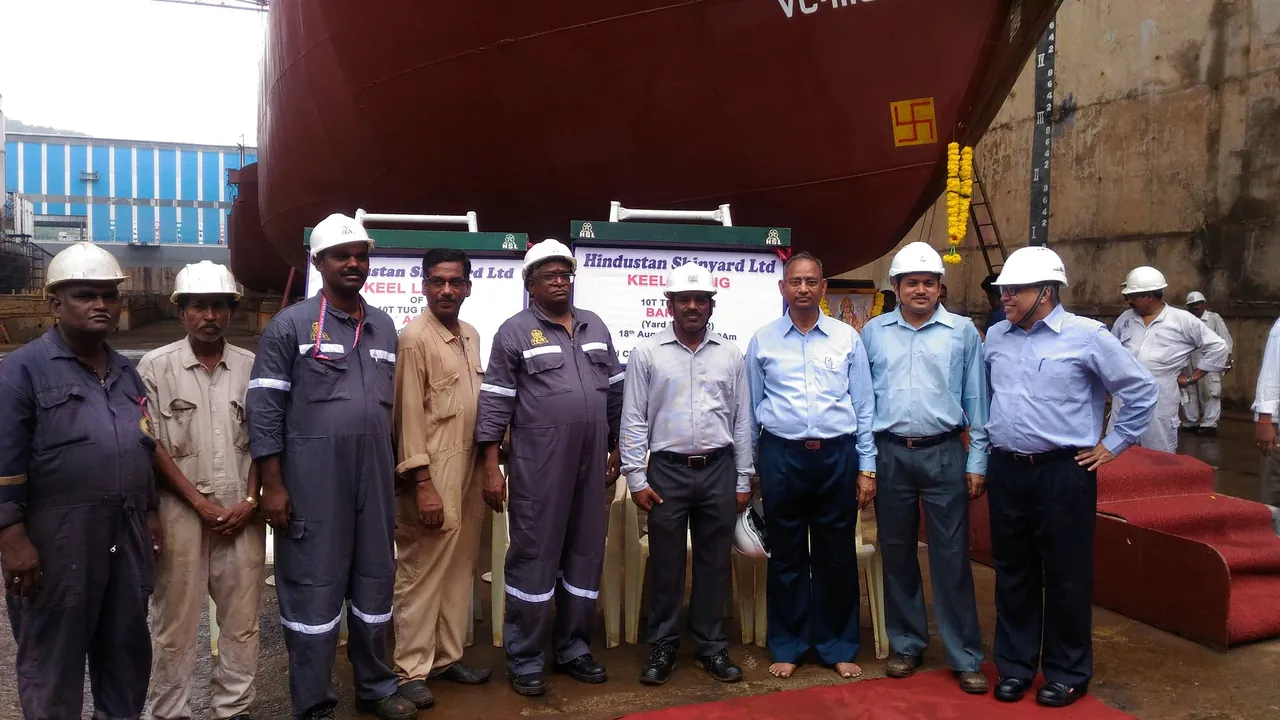 Project personnel with a tug hull during construction at HSL.